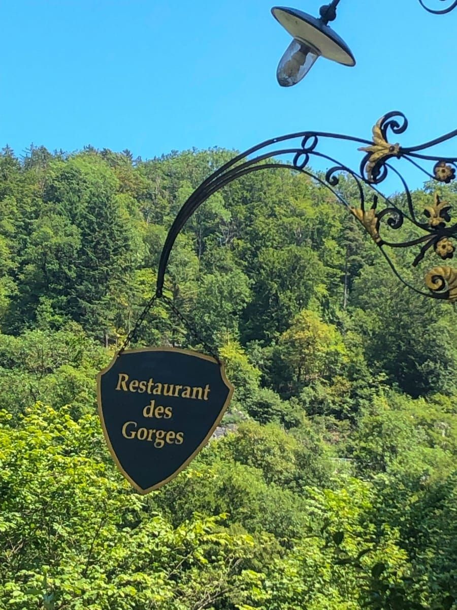 Das Schild des Restaurant des Gorges vor dichtem grünem Wald
